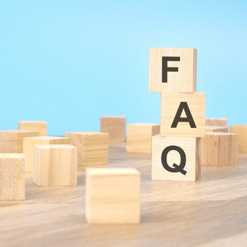 FAQ - short for Frequency Asked Questions - written on a wooden cube, business concept. blue background